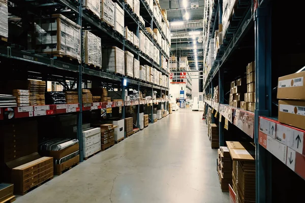 Grande armazém com fileiras de prateleiras e caixas de mercadorias . — Fotografia de Stock