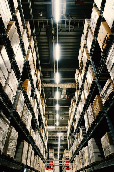 Grande armazém com fileiras de prateleiras e caixas de mercadorias . — Fotografia de Stock