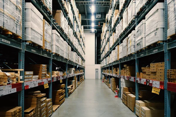 Grande armazém com fileiras de prateleiras e caixas de mercadorias . — Fotografia de Stock