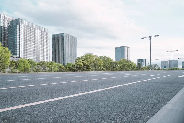 도쿄의 현대 도시에 나무와 도로가 있는 그룹 빌딩. - 이미지 스톡 사진