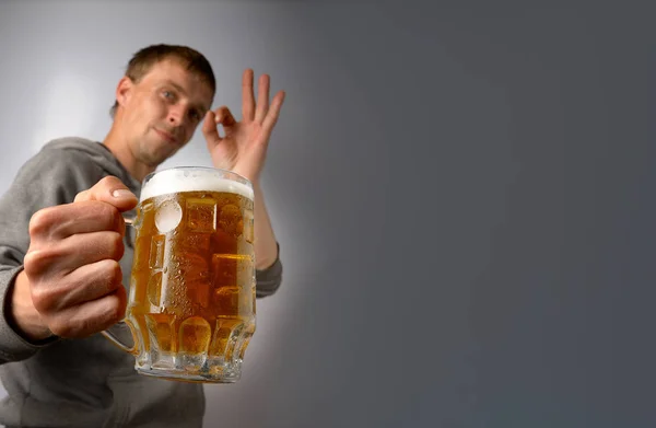 O cara oferece e elogia uma caneca de cerveja leve — Fotografia de Stock