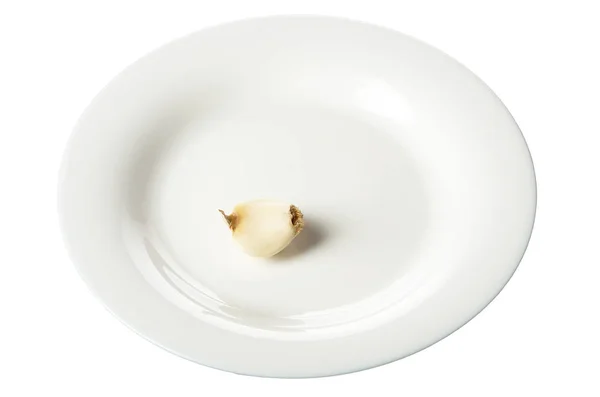 白色盘子，白色上分离出一片大蒜 — 图库照片