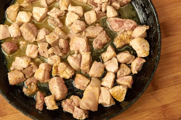 Carne, cozida na panela, cortada em cubos em uma tábua de madeira — Fotografia de Stock