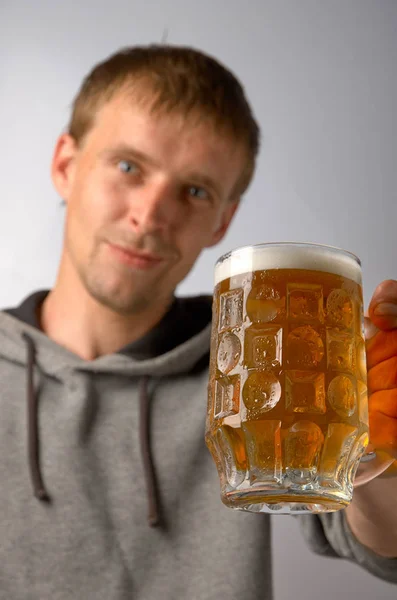 O tipo oferece uma caneca de cerveja gelada. — Fotografia de Stock