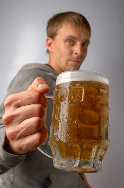 Der Mann im Fahrrad bietet einen Becher leichtes kaltes Bier an — Stockfoto