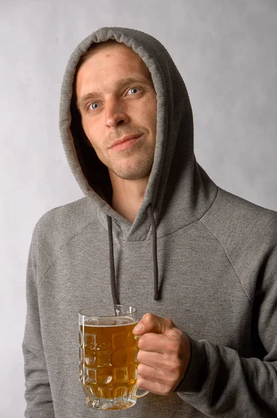 Jovem segurando uma caneca de cerveja leve fria — Fotografia de Stock