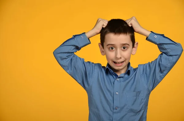 The boy hands clinging to the hair on a yellow background