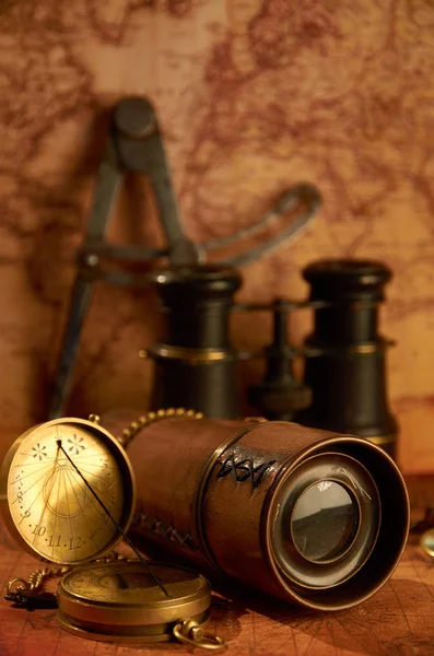 Old telescope with binoculars on map background