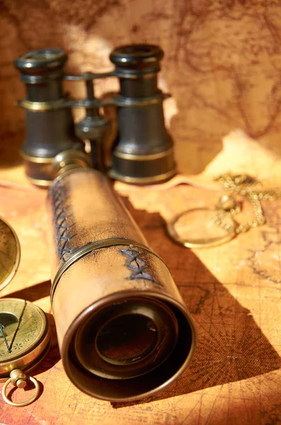 Old binoculars and telescope lying on the map