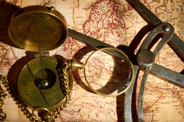 Old compass and magnifying glass lying on the map — Stock Photo, Image