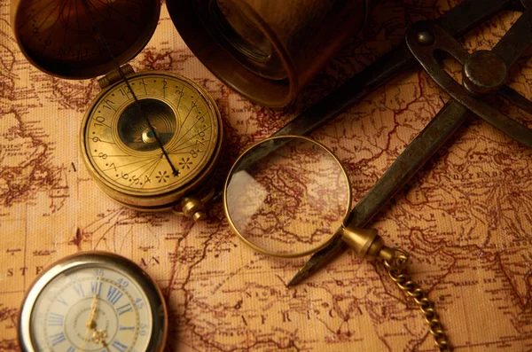 Old clock with compass and shameful pipe lying on paper map — Stock Photo, Image