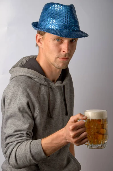 Jovem de chapéu azul com um copo de cerveja light — Fotografia de Stock