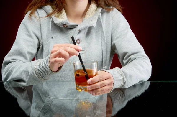 Menina e bebida alcoólica com palha e gelo no fundo vermelho — Fotografia de Stock