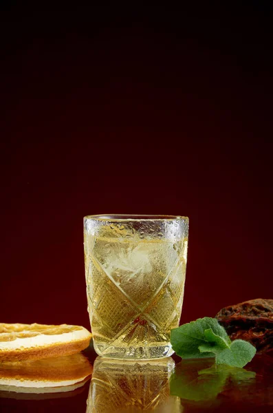 Óculos com bebidas alcoólicas fortes com gelo e hortelã em um fundo vermelho — Fotografia de Stock