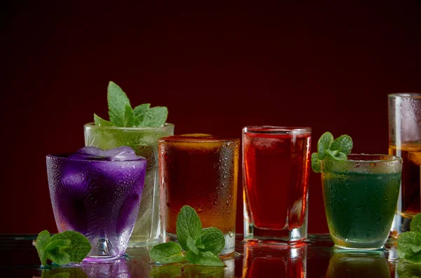 Set alkoholischer Cocktails mit Eis und Minze auf rotem Hintergrund — Stockfoto