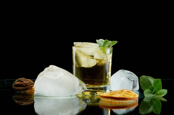 Cocktail alcolico freddo con arancia ghiacciata ed erbe fresche su fondo nero — Foto Stock