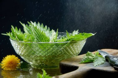 Siyah bir arka planda cam vazo içinde ısırgan salatası