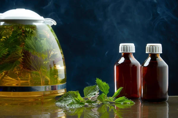 Bule de chá de urtiga fresca e folhas de urtiga em um ambiente médico em um fundo preto — Fotografia de Stock