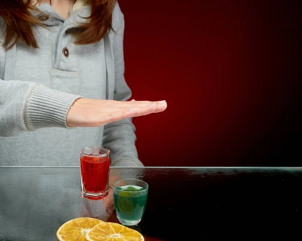 Rifiuto di offrire di bere alcol con ghiaccio in un bicchiere trasparente su sfondo rosso — Foto Stock