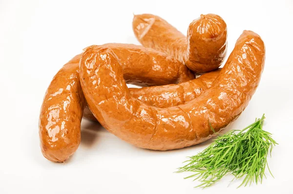 Grilled sausages with green dill on white background, street food. Juicy sausages. Sausages for the picnic. Fast food. Harmful food on a light background. Fatty food. — Stock Photo, Image