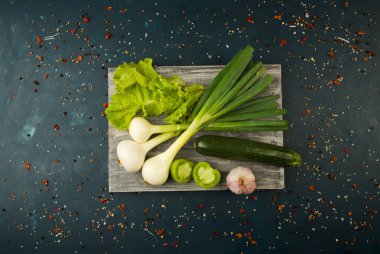 Taze Sebze ve Baharatlar Bir Ahşap Tahta Üzerine Koyu Taş Arka Plan. Vintage kavramı. Baharatlar Karanlık Bir Yüzey üzerinde Genç Mısır Kuşkonmaz Yeşil Domates Salatalık.