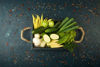 Koyu taş arka plan üzerinde ahşap kutu üzerinde taze sebze. Vintage kavramı. Genç Mısır Soğan Kuşkonmaz Yeşil Domates Salatalık Karanlık Bir Yüzey üzerinde.