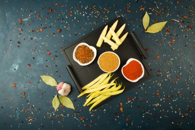 Koyu Bir Arka Plan Üzerinde Kutu içinde Baharatlar. Koyu Dokulu Arka Plan Üzerine Kolları ile Ahşap Tepsi Üzerinde Duran Parlak Baharatlar Yemekleri.