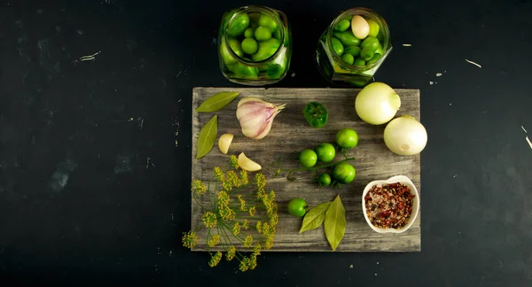 VEGETALES TOMATOS Y ESPECIAS EN EL CONSEJO. Las cebollas GARLIC TOMATOES DILL SPICES ON GREY WOODEN BOARD ON A RaISED STONE SURFACE. EL CONCEPTO DE LA SALTACIÓN. — Foto de Stock