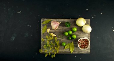 Sebzeler yönetim kurulunda. Gri tahta sörf tahtasının üzerinde asılı duran soğanlı sarımsaklı domatesler..