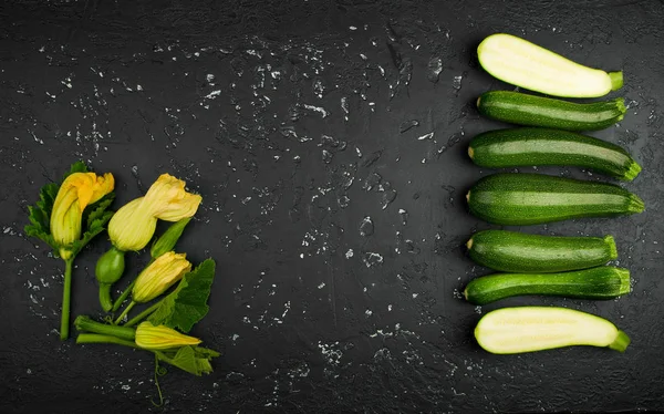 Fresh green zucchini on a dark table. The view from the top. Cop