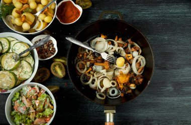 Arka planda sebzeler var. Bir tabakta kızarmış kabak sosu. Bir kase dereotu ile genç haşlanmış patates. Tavada altın soğan ile kızarmış chanterelle mantar. kopyalama alanı