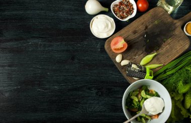 Sebzeli salata. Yukarıdan görüntüleyin. Koyu renkli bir arka plandaki tabakta taze salata. Sarımsak, domates, salatalık, dereotu ve soğan koyu yüzeybir tabak. Kopyalama alanı.
