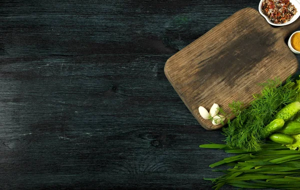 Ensalada con verduras. Vista desde arriba. Ensalada fresca en un plato sobre un fondo oscuro. Ajo, tomate, pepino, eneldo y cebolla en un plato de superficie oscura. Copiar espacio . — Foto de Stock