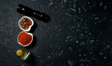 Arka planda baharat. Baharatlar, yağ, tuz koyu dokulu bir yüzeyde. Yukarıdan görüntüleyin. Ücretsiz kopyalama alanı.