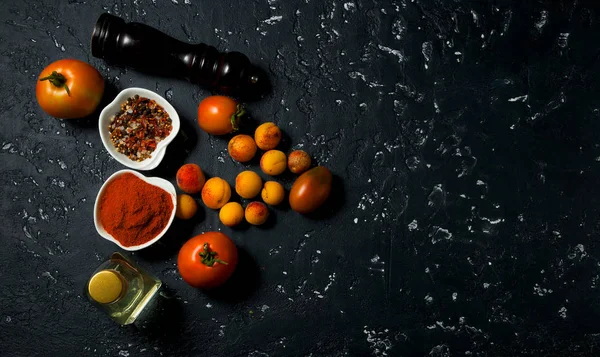 Verduras sobre un fondo oscuro. Especias, aceite, calabacín, tomate, melocotones en una superficie de textura oscura. Vista desde arriba. espacio de copia . — Foto de Stock