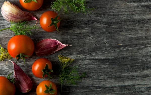 Tomates en el fondo. Los tomates, el ajo sobre la superficie de madera. Vista desde arriba. Verduras frescas. espacio de copia . — Foto de Stock