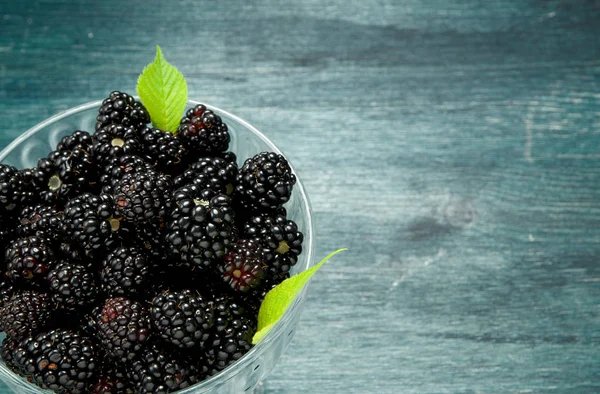 Fresh blackberry. Juicy blackberry in a bowl on a wooden table. View from above. Copy space. Harvest concept