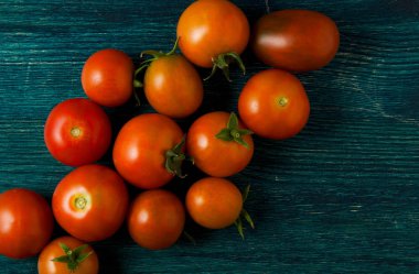 Arka planda domatesler var. Domates, sarımsak tahta bir yüzeyde. Yukarıdan görüntüleyin. Taze sebzeler. kopyalama alanı.