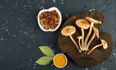 Siyah tahtaüzerinde baharat ve otlar ile taze mantar. Şundan görüntüle 