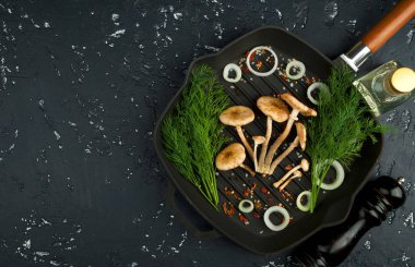 Siyah tahtaüzerinde baharat ve otlar ile taze mantar. Şundan görüntüle 