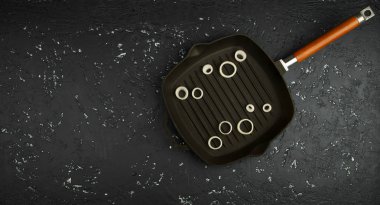 Koyu bir masada bir tavada taze doğranmış soğan. Yukarıdan görüntüleyin. Kopyalama alanı