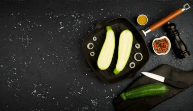 Koyu bir masada tavada taze yeşil kabak. Yukarıdan manzara. Boşluğu kopyala.