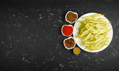 Sebzeli bir tabakta taze fasulye, karanlık bir masada. Yukarıdan bak. Boşluğu kopyala