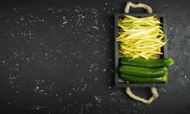 Koyu bir masanın üzerindeki bir kutuda taze fasulye. Yukarıdan görüntüleyin. Kopyalama alanı