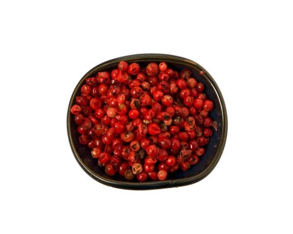 Red pepper in a bowl on isolate. View from above. Seasoning with peas of red pepper isolated on a white background. Close-up. — Stock Photo, Image