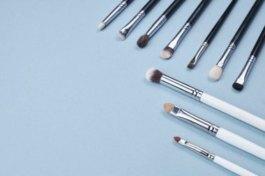 Makyaj için fırçalar ya da mavi arka plana çizimler. metin için boşluk kopyala. en üstteki görünüm