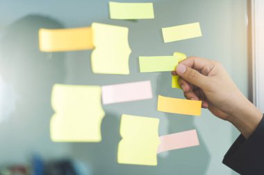 Cam pencerede yapışkan notları tutarak el