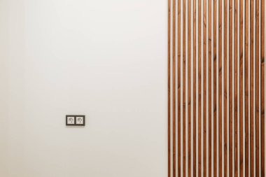 Arka plan beyaz duvar, tahta kahverengi çıtçıtalar ve solunda küçük bir roset var.