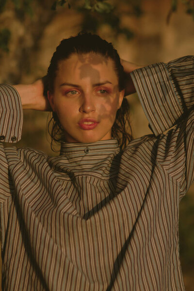 Young beautiful brunette on the lake with wet hair and light mak