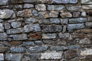 Eski taş duvar gri ve kahverengi çeşitli tonları taş ile kaplıdır. Arka plan.